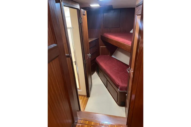 Long Tail Yacht Photos Pics Interior of 1985 Hatteras 58 Motor Yacht with wooden bunk beds and red bedding.
