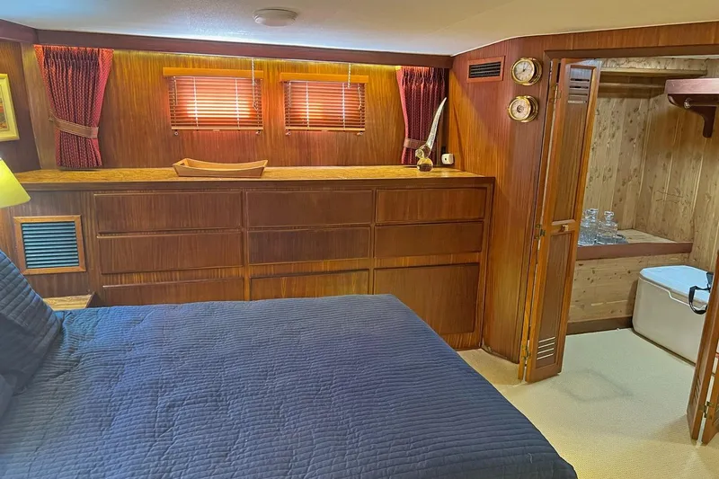 Long Tail Yacht Photos Pics 1985 Hatteras 58 Motor Yacht interior with wood paneling, bed, and storage.