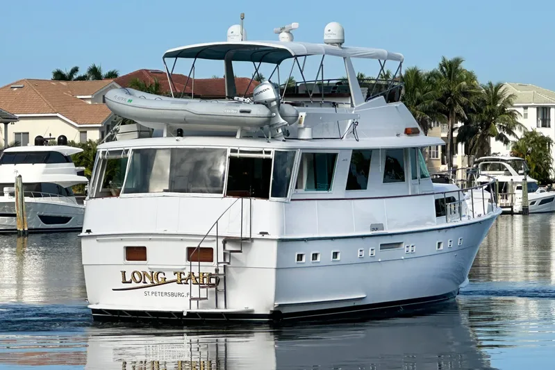 Long Tail Yacht Photos Pics 1985 Hatteras 58 Motor Yacht docked in a scenic marina setting.