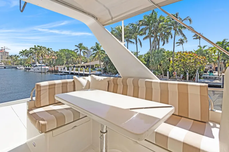Simbra Yacht Photos Pics Luxury seating area on 2006 Norseman 480S yacht, with waterfront view and palm trees.