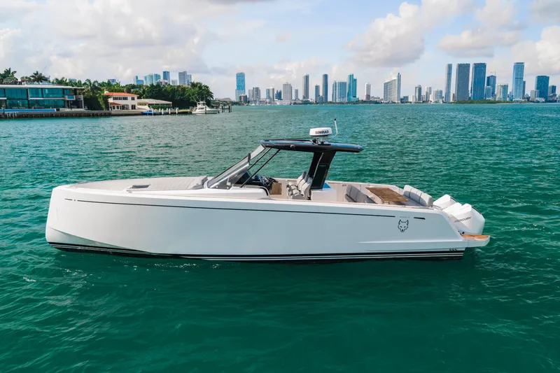 The Wolf Yacht Photos Pics 2021 Pardo Yachts 38 cruising on turquoise water with city skyline backdrop.