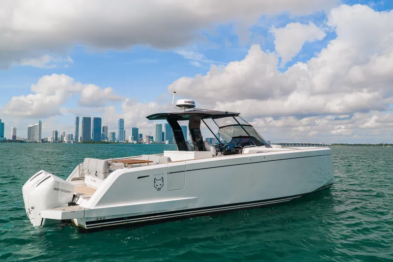 The Wolf Yacht Photos Pics 2021 Pardo Yachts 38 cruising on water with city skyline in background.