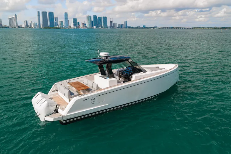 The Wolf Yacht Photos Pics 2021 Pardo Yachts 38 cruising on turquoise waters with city skyline in background.