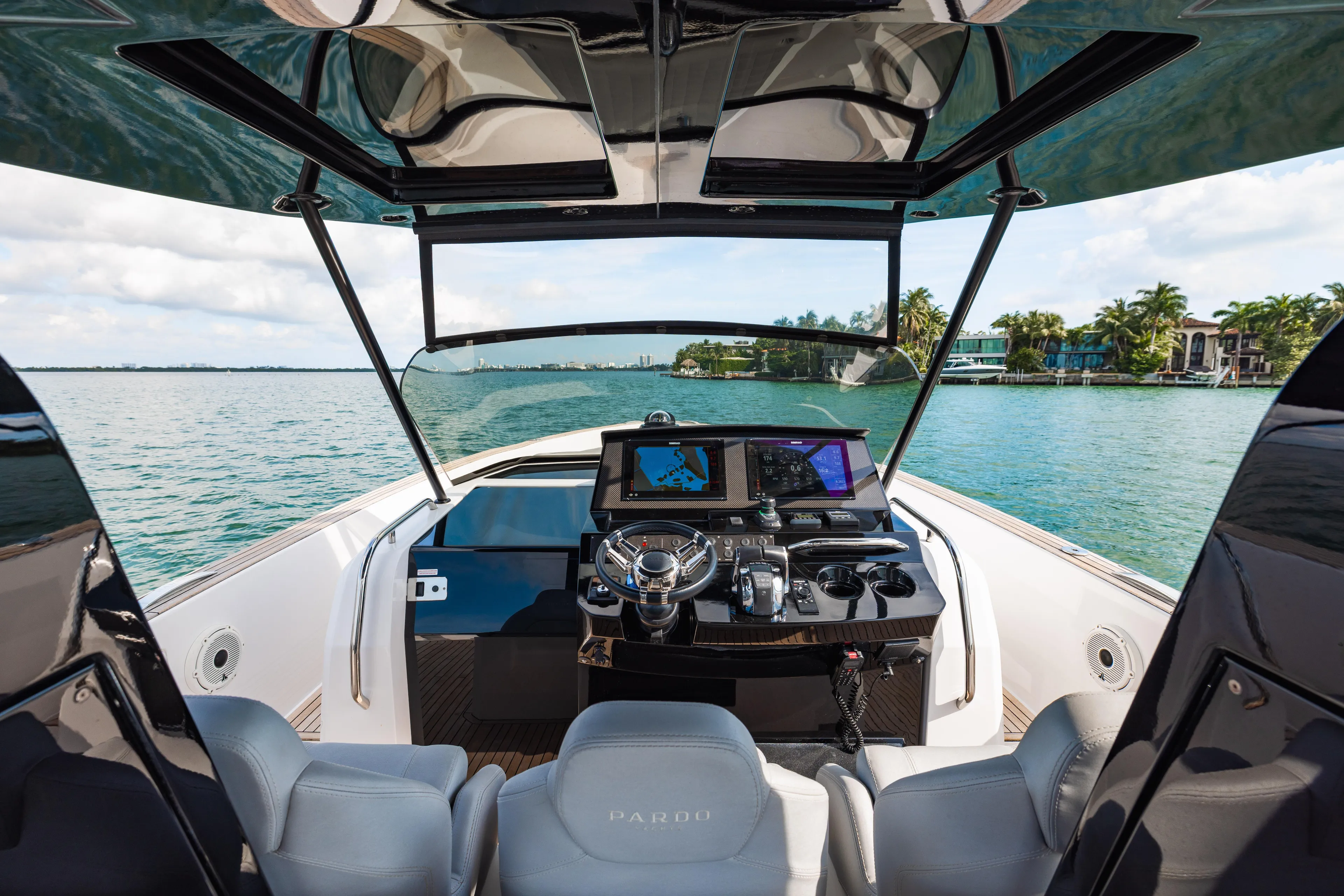 The Wolf Yacht Photos Pics 2021 Pardo Yachts 38 cockpit with modern controls, cruising on a scenic waterway.