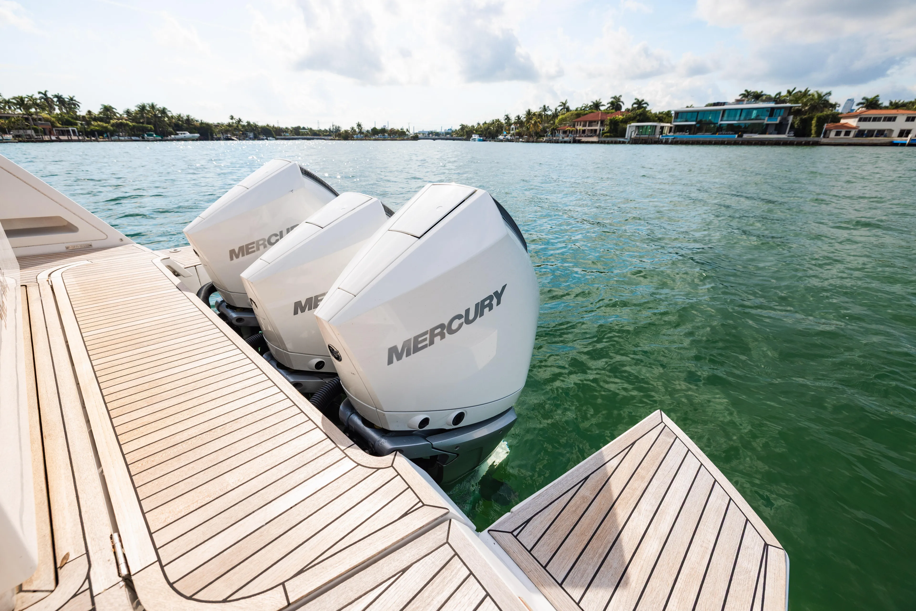 The Wolf Yacht Photos Pics 2021 Pardo Yachts 38 with Mercury engines on a wooden deck, near waterfront homes.