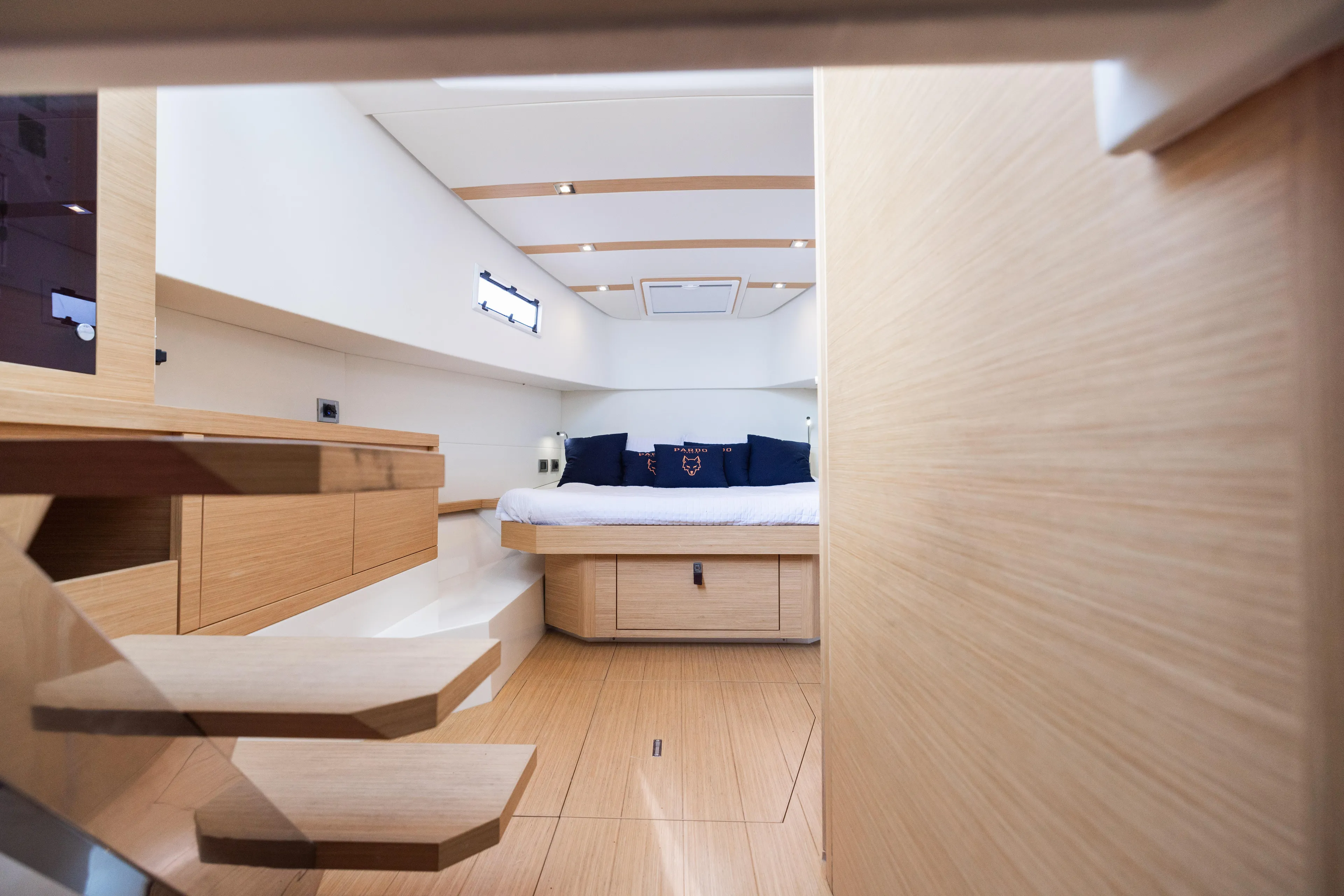 The Wolf Yacht Photos Pics Luxurious interior of 2021 Pardo Yachts 38, featuring modern wood finishes and cozy bedding.