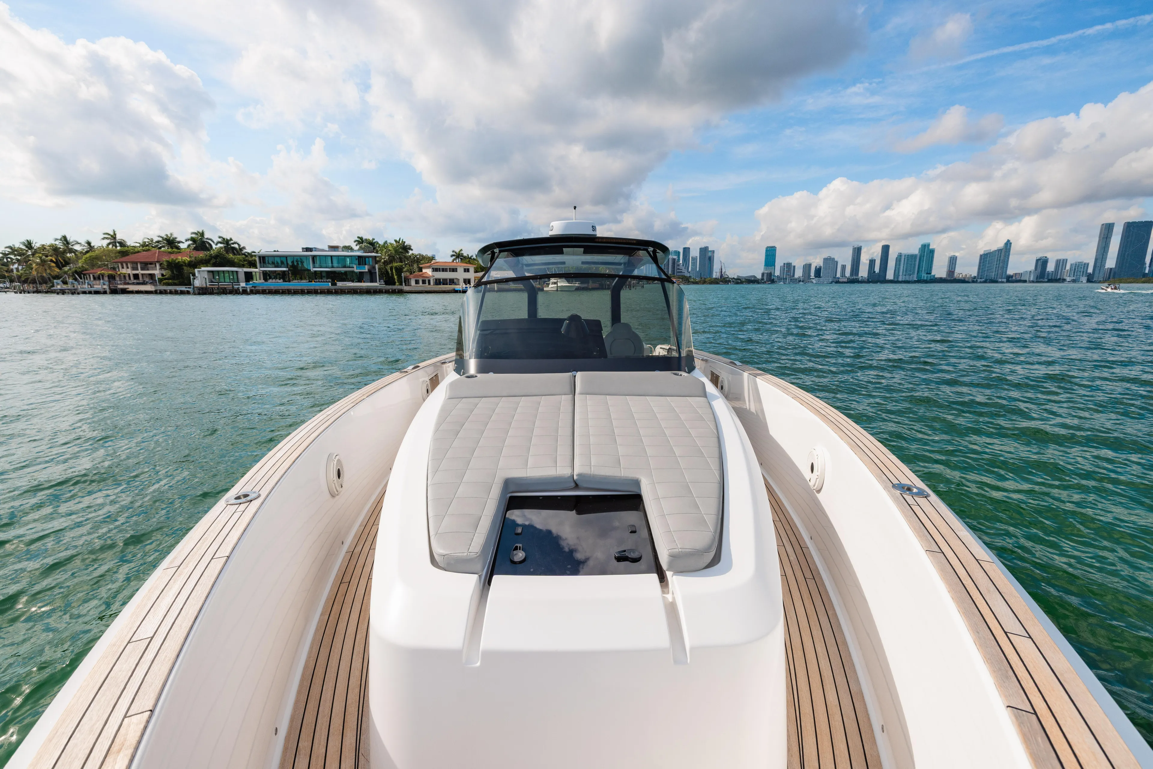 The Wolf Yacht Photos Pics 2021 Pardo Yachts 38 on water with city skyline and luxury homes in background.