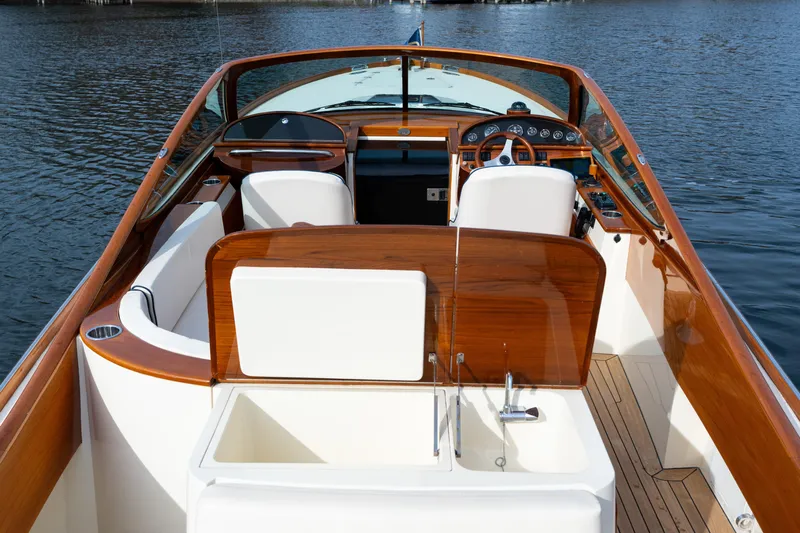 Ballymena Yacht Photos Pics 2006 Hinckley Talaria 29 R boat interior with wooden accents and white seating on water.