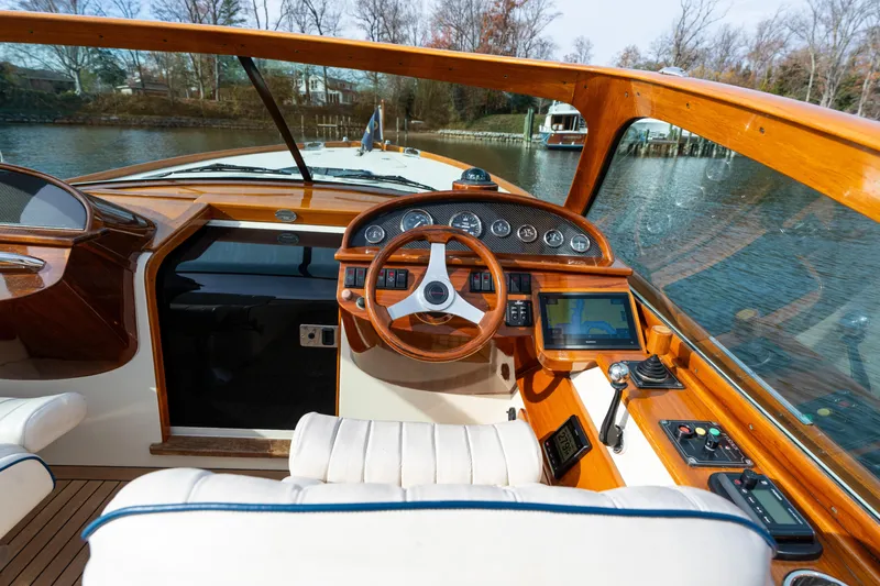 Ballymena Yacht Photos Pics Interior of a 2006 Hinckley Talaria 29 R boat with wooden dashboard and steering wheel.