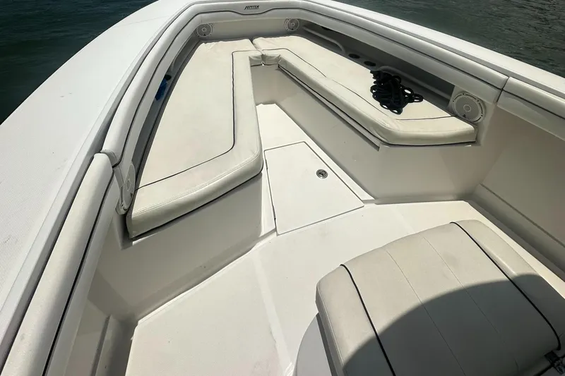  Yacht Photos Pics 2014 Jupiter 30 HSF boat interior with white cushioned seating and storage compartments.