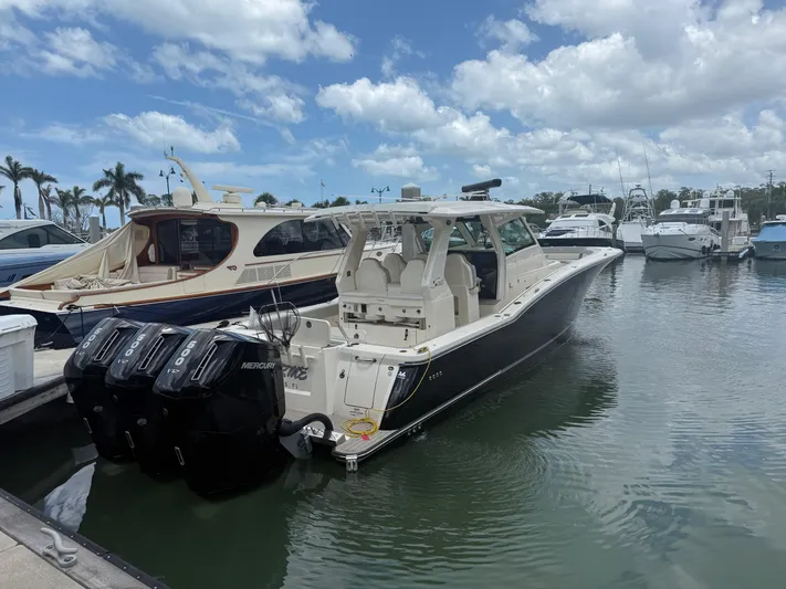  Yacht Photos Pics 2022 Scout 425 LXF boat docked in marina with multiple outboard engines.