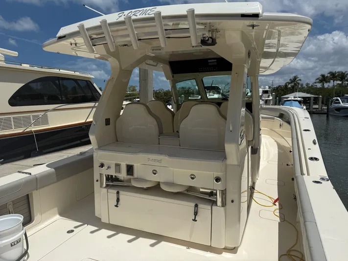  Yacht Photos Pics 2022 Scout 425 LXF boat interior with seating and helm, docked under a clear sky.