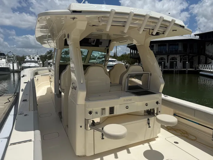  Yacht Photos Pics 2022 Scout 425 LXF boat with spacious deck and seating, docked at marina under blue sky.