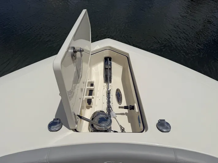  Yacht Photos Pics 2022 Scout 425 LXF boat anchor compartment with open hatch, showcasing marine equipment.