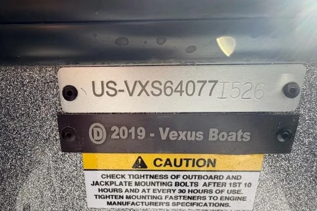 Hull identification number on a Vexus DVX22 boat, model year 2026, with caution label.