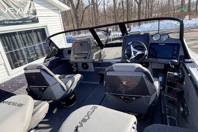2026 Vexus DVX22 boat interior with modern dashboard and seating, parked outdoors.