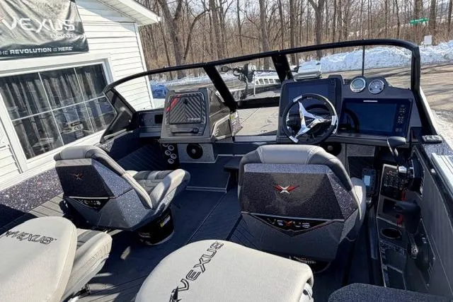2026 Vexus DVX22 boat interior with modern dashboard and seating, parked outdoors.