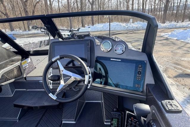 2026 Vexus DVX22 boat dashboard with steering wheel and digital displays in snowy setting.