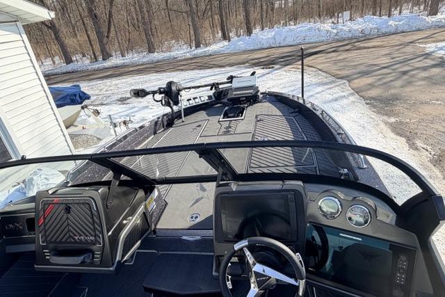 2026 Vexus DVX22 boat interior with advanced dashboard and steering, parked in snowy setting.