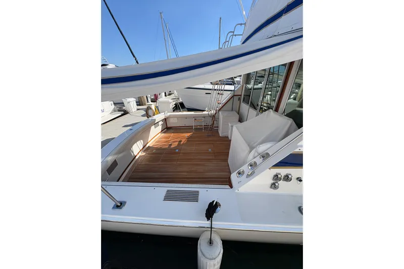 Sea Legs Yacht Photos Pics 1987 Bertram 46.6 yacht with spacious wooden deck and marina view.