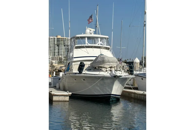 Sea Legs Yacht Photos Pics 1987 Bertram 46.6 yacht docked in marina, clear sky, American flag visible.