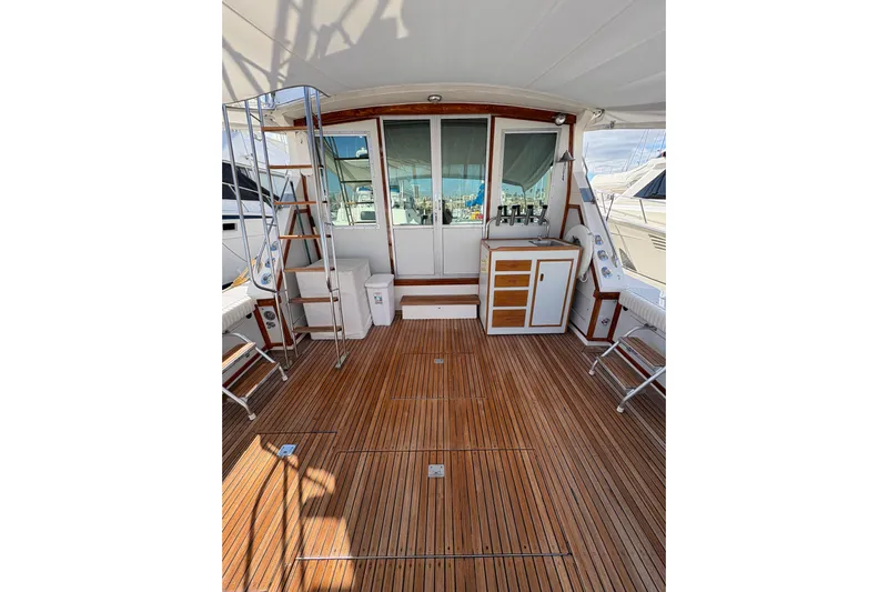 Sea Legs Yacht Photos Pics 1987 Bertram 46.6 yacht deck with wooden flooring and ladder.