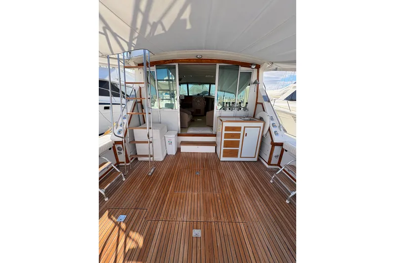 Sea Legs Yacht Photos Pics 1987 Bertram 46.6 yacht interior with wooden deck and seating area.