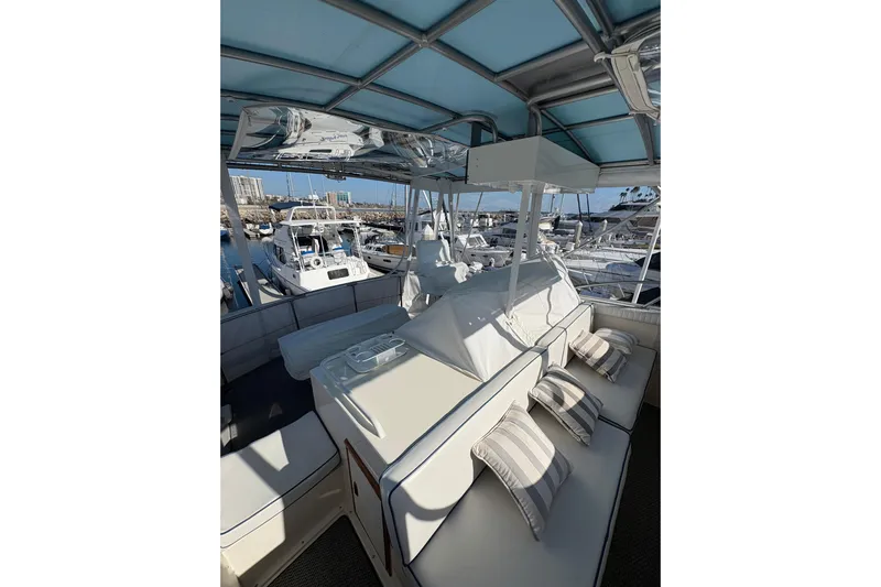 Sea Legs Yacht Photos Pics 1987 Bertram 46.6 yacht interior with cushioned seating and marina view.