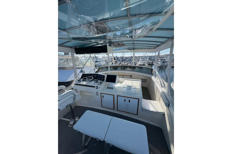 Sea Legs Yacht Photos Pics 1987 Bertram 46.6 yacht cockpit with helm, seating, and marina view.