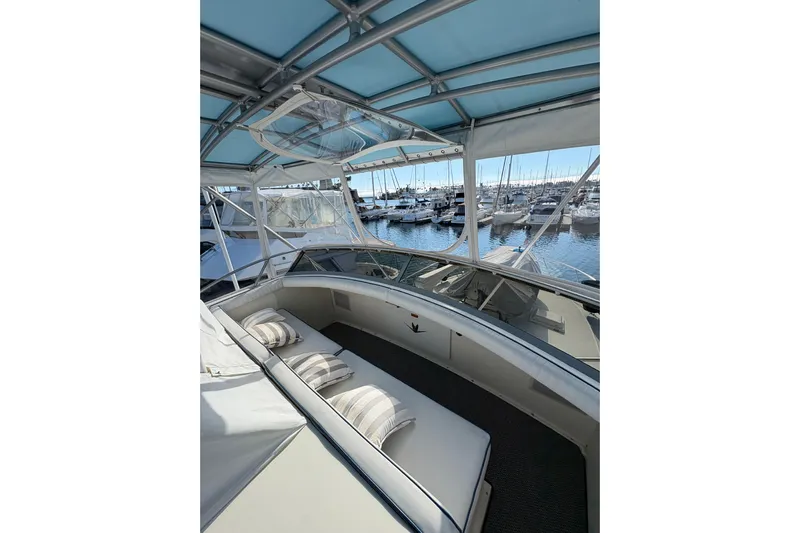 Sea Legs Yacht Photos Pics 1987 Bertram 46.6 yacht interior with cushioned seating, docked at marina.