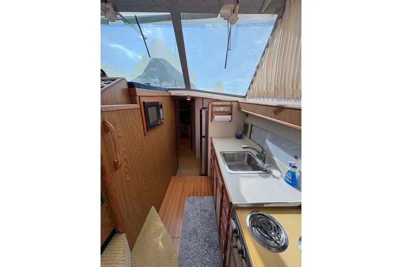 Sea Legs Yacht Photos Pics Interior of 1987 Bertram 46.6 yacht featuring kitchen area with sink and stove.