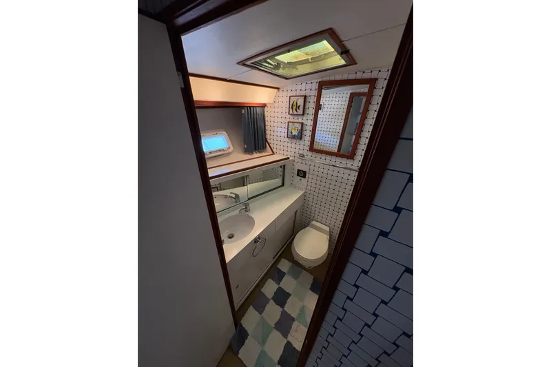 Sea Legs Yacht Photos Pics Bathroom interior of 1987 Bertram 46.6 yacht with modern fixtures and nautical decor.