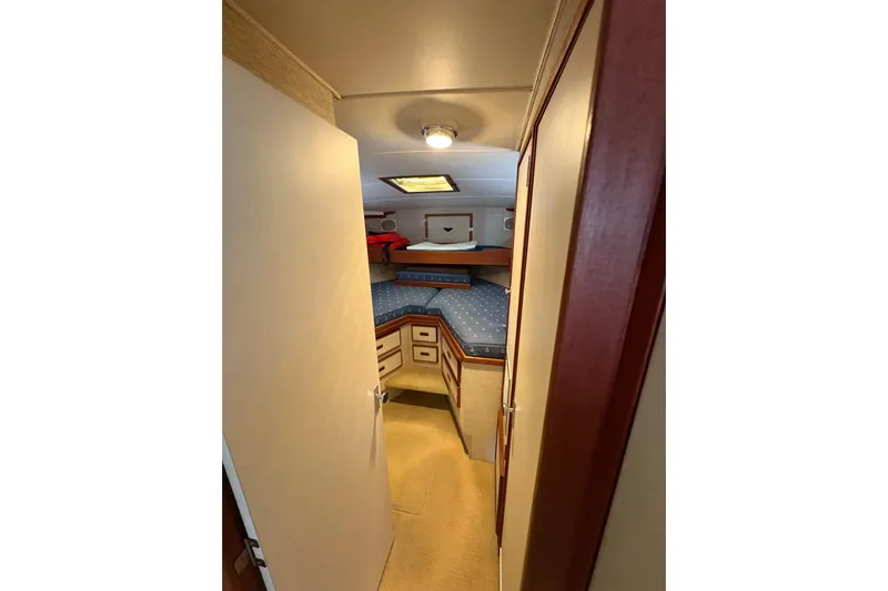 Sea Legs Yacht Photos Pics Interior cabin of 1987 Bertram 46.6 yacht with cozy bedding and storage.