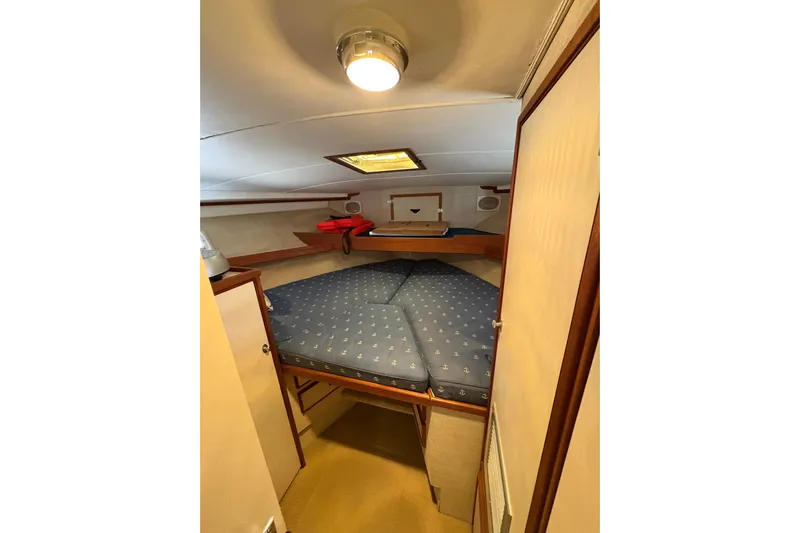 Sea Legs Yacht Photos Pics Cozy cabin interior of 1987 Bertram 46.6 yacht with blue bedding and wooden accents.