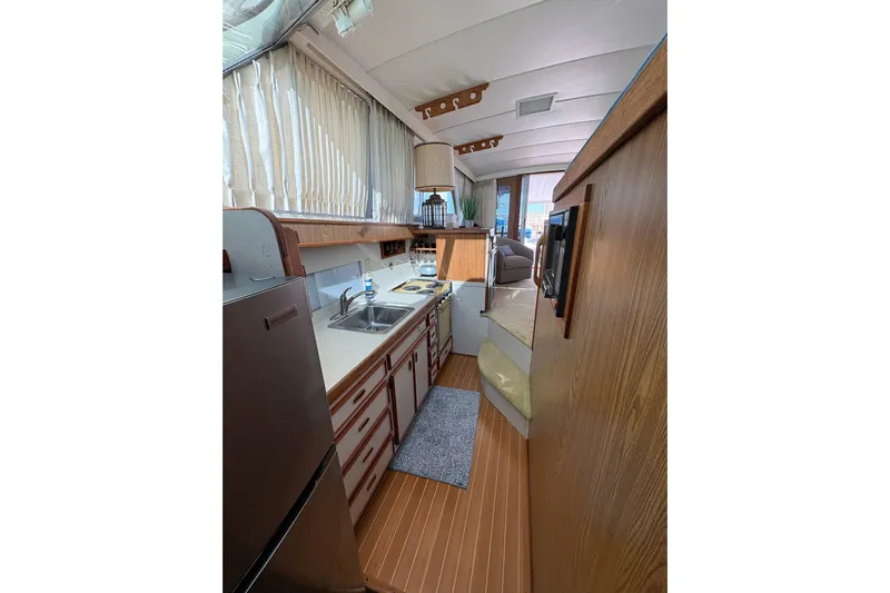 Sea Legs Yacht Photos Pics Interior of 1987 Bertram 46.6 yacht, featuring kitchen area with wood accents and appliances.