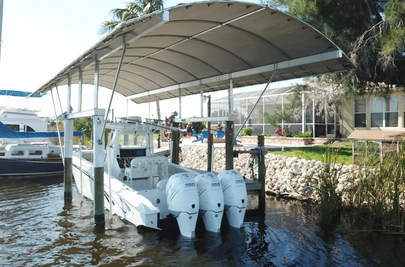  Yacht Photos Pics 2008 Fountain 34 CC boat docked under canopy with triple outboard engines.