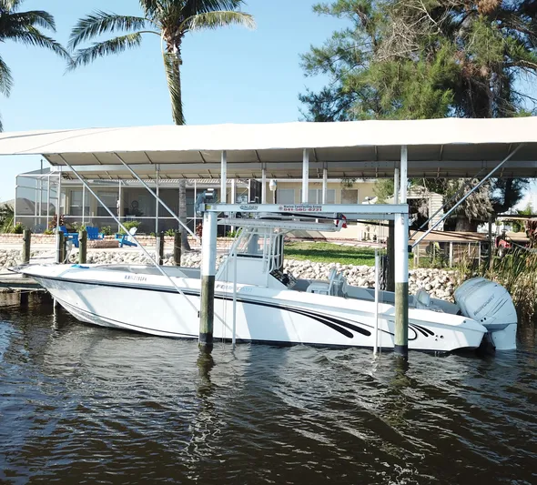  Yacht Photos Pics 2008 Fountain 34 CC boat docked under canopy with palm trees in background.