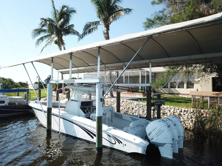  Yacht Photos Pics 2008 Fountain 34 CC boat docked under canopy with palm trees in background.