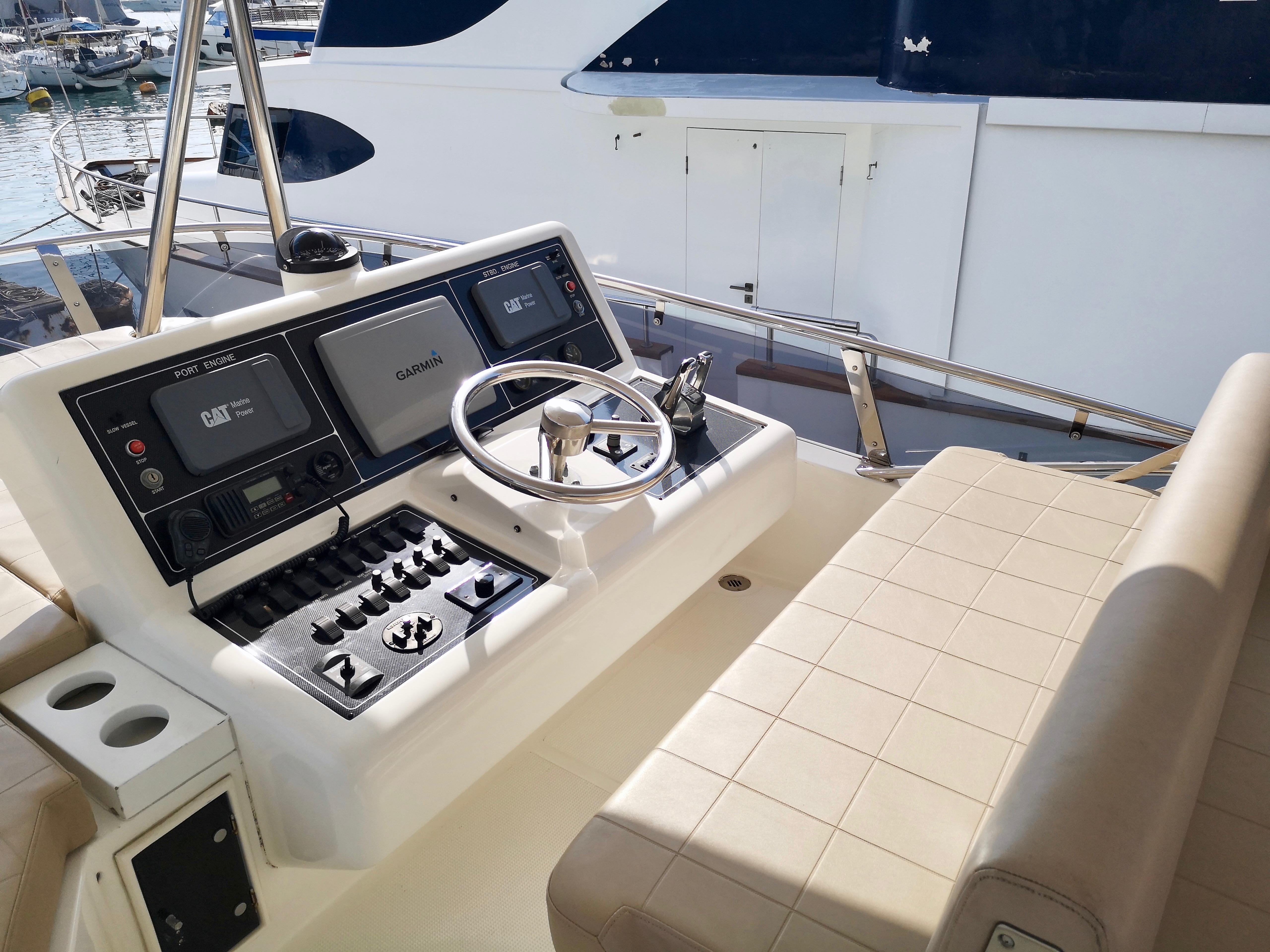 Control panel of a 2012 Ruby 65s yacht with steering wheel and navigation equipment.