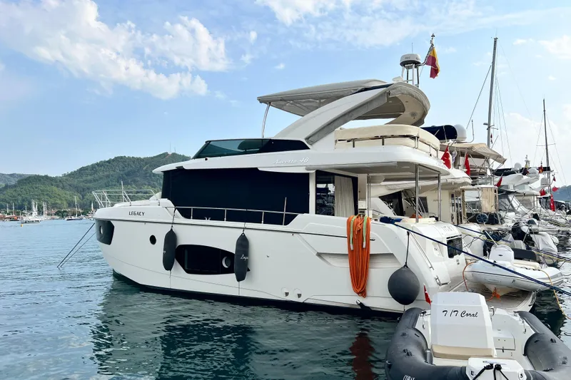 48 Navetta Yacht Photos Pics 2019 Absolute NAVETTA 48 yacht docked in a scenic marina with mountainous backdrop.