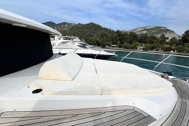 48 Navetta Yacht Photos Pics Luxurious 2019 Absolute NAVETTA 48 yacht with sunbathing deck, docked by scenic coastline.