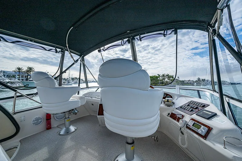 Feliz Dream Yacht Photos Pics 2001 Sea Ray 400 Sedan Bridge cockpit with white captain chairs and panoramic view.