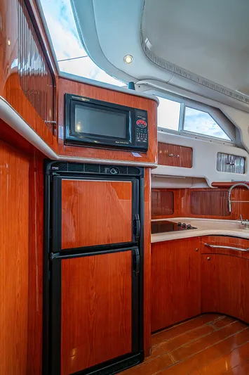 Feliz Dream Yacht Photos Pics 2001 Sea Ray 400 Sedan Bridge kitchen with wood cabinetry and modern appliances.