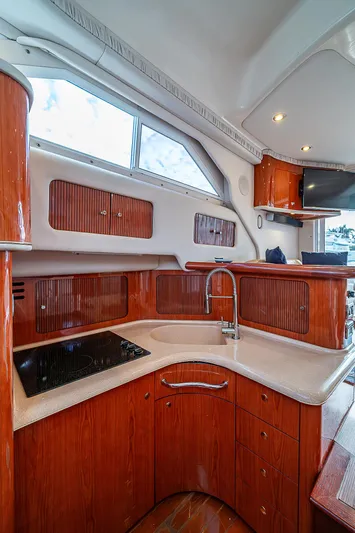 Feliz Dream Yacht Photos Pics 2001 Sea Ray 400 Sedan Bridge kitchen with wood cabinetry and modern fixtures.