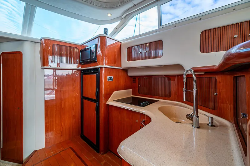 Feliz Dream Yacht Photos Pics 2001 Sea Ray 400 Sedan Bridge yacht kitchen with wood cabinetry and modern appliances.