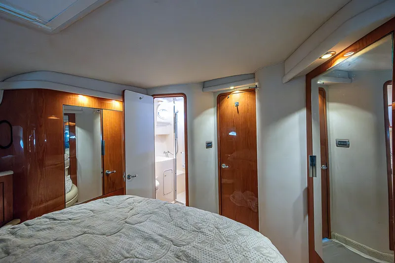 Feliz Dream Yacht Photos Pics Interior of 2001 Sea Ray 400 Sedan Bridge, featuring wood paneling and cozy bedroom.