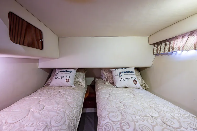Feliz Dream Yacht Photos Pics Twin beds in the 2001 Sea Ray 400 Sedan Bridge cabin, featuring nautical-themed pillows.