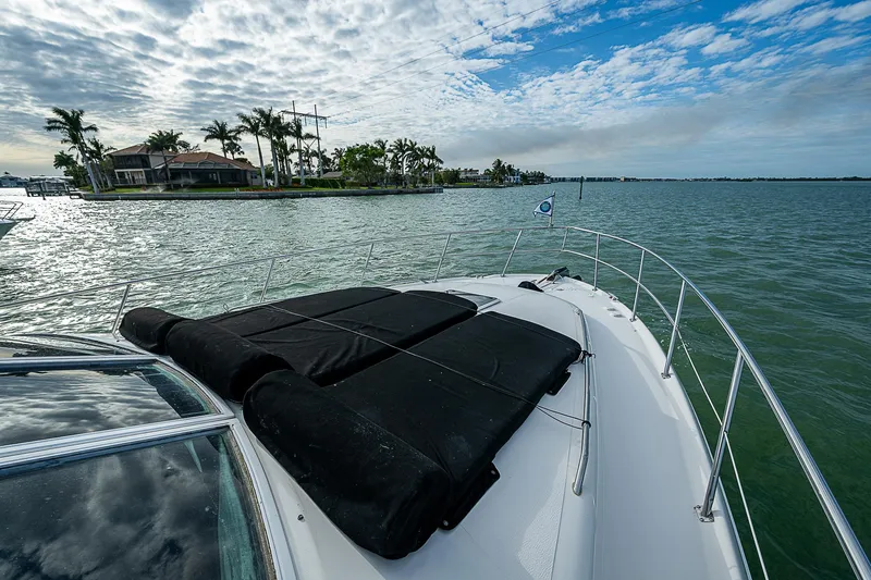 Feliz Dream Yacht Photos Pics 2001 Sea Ray 400 Sedan Bridge cruising on a scenic waterway with palm trees and cloudy sky.