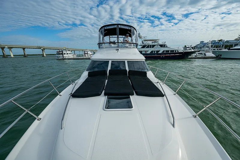 Feliz Dream Yacht Photos Pics 2001 Sea Ray 400 Sedan Bridge yacht on water, with bridge and boats in background.