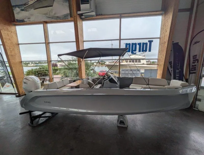 2023 Rand Source 22 boat displayed indoors with canopy and seating.